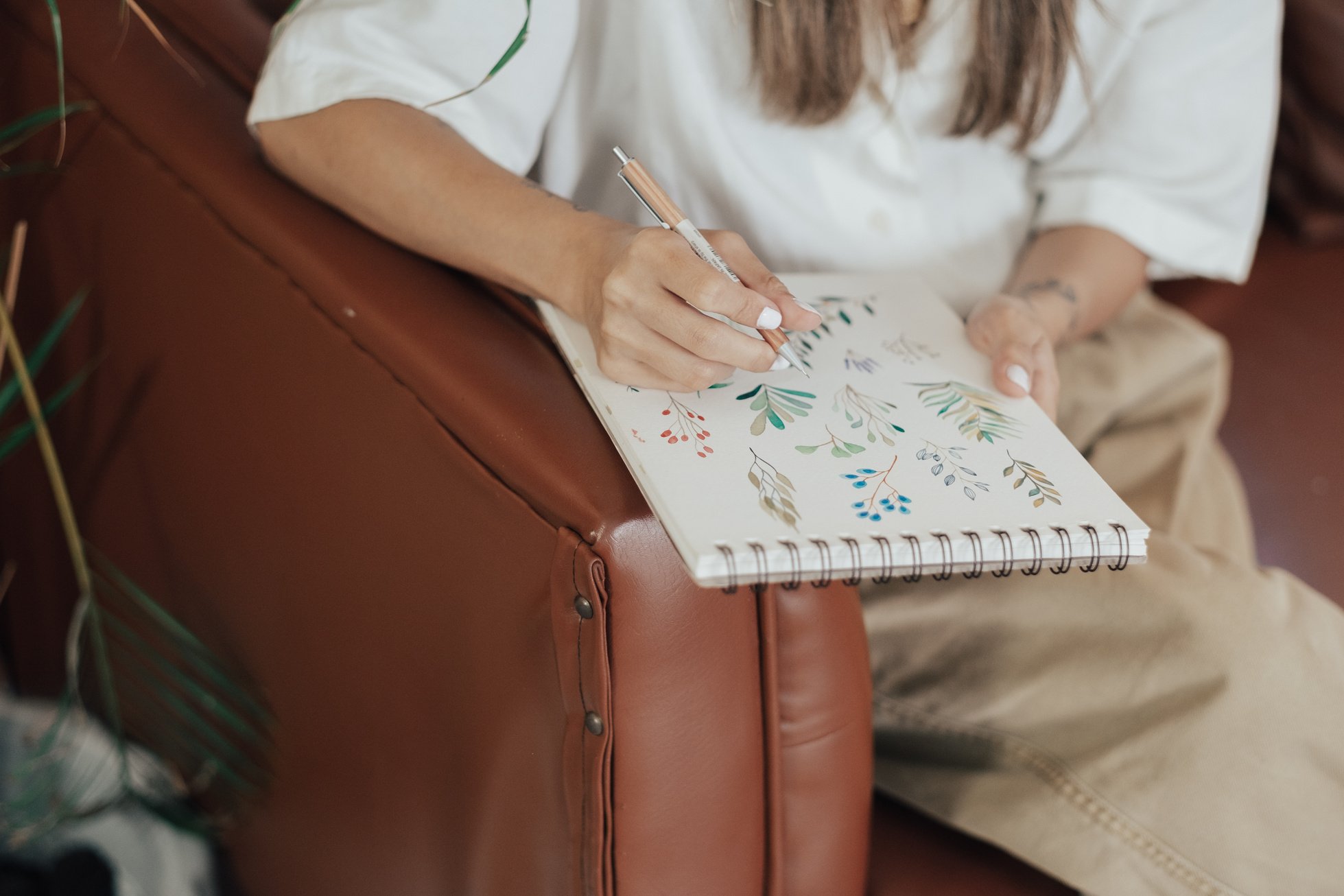 Female Designer Drawing in Notepad in Studio